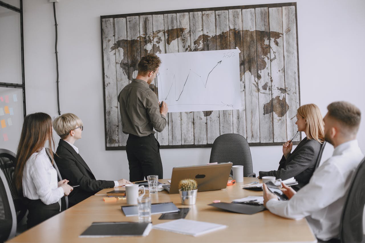 why-choose-us Group of business professionals discussing strategies with growth chart in conference room.