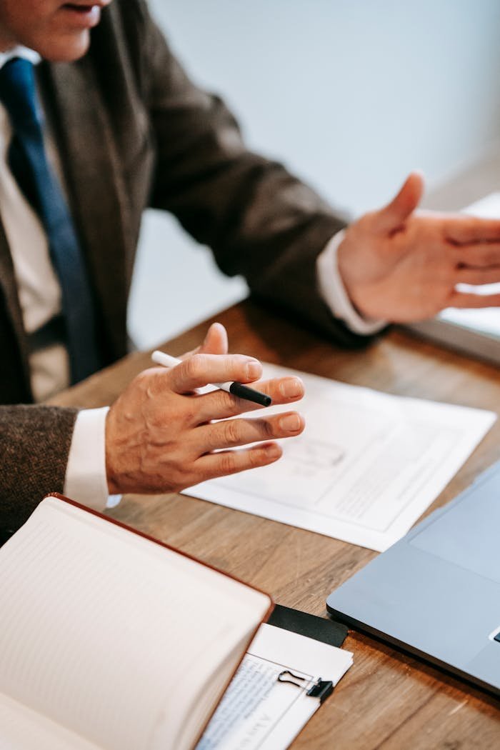Architecting Scale: Why Strategic Consulting is the Catalyst for Sustained Growth Professional discussing documents over a wooden table in an office setting.
