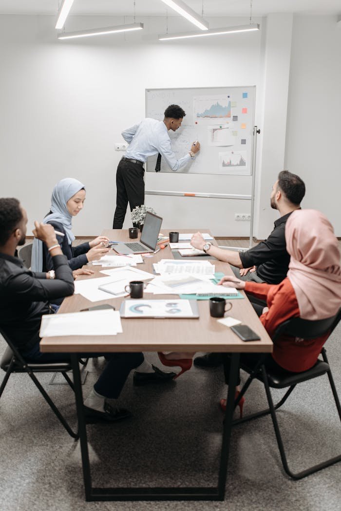 Welcome to Reitaway Consulting: Navigating Your Path to Scale An office team of mixed ethnicities collaborating in a modern meeting room.